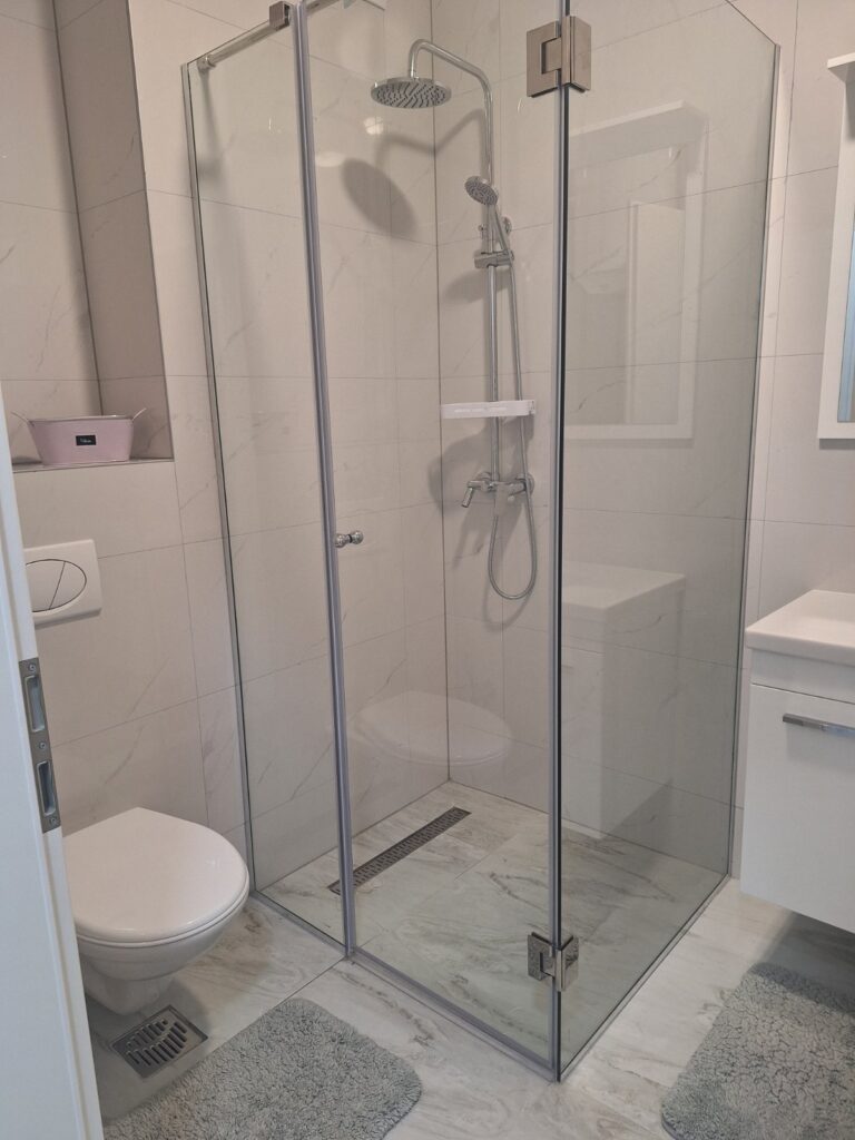 Kupatilo apartmana Tuzla Tower Apt sa modernom tuš kabinom i elegantnim uređenjem