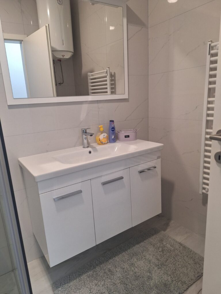 Moderno kupatilo apartmana Tuzla Tower Apt sa umivaonikom, ogledalom i ormarićem